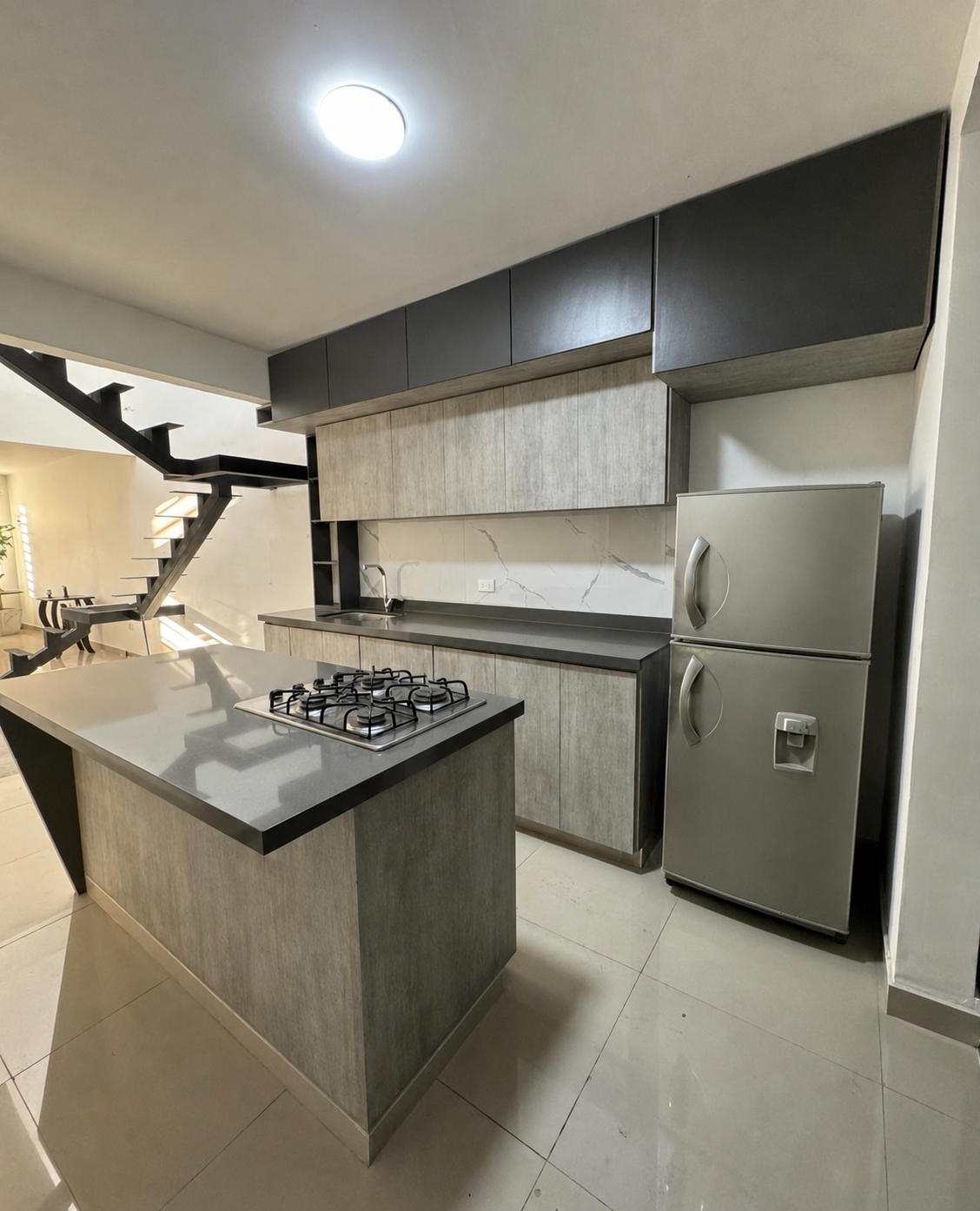 Cocina integral gris con isla fabricada por The Marble House